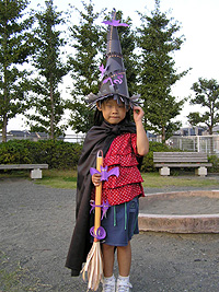 帽子とほうきで魔女の完成。黒い布をマント代わりにすると、魔女度がアップ